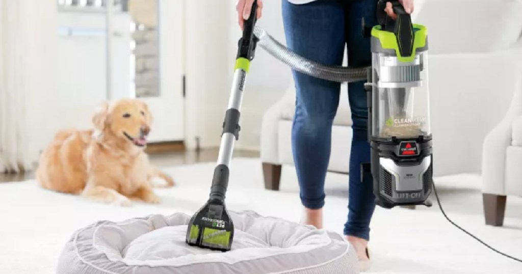woman vacuuming pet bed
