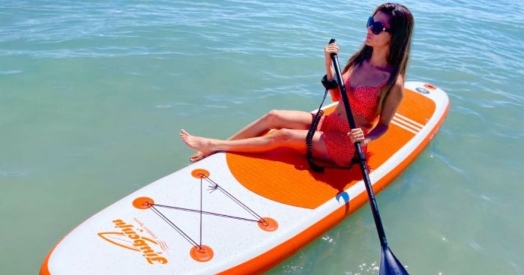 woman sitting on a paddle board