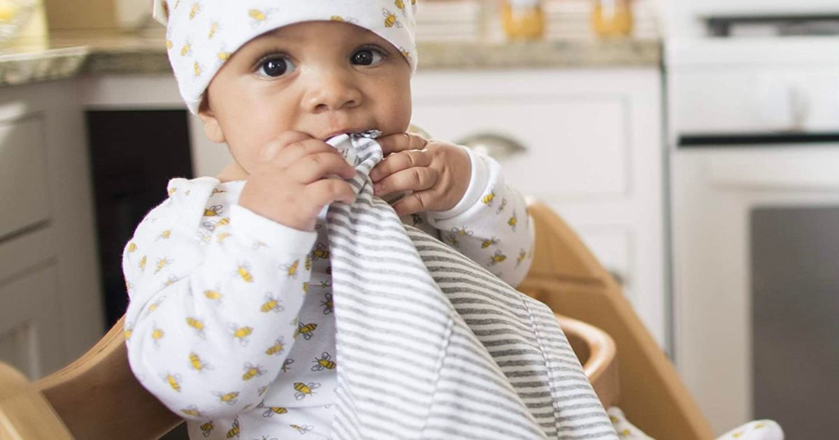 a baby chewing on the corner of a Burts bees baby organic burp cloths
