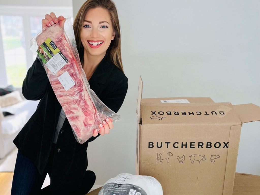 woman holding up a rack of ribs from a butcherbox
