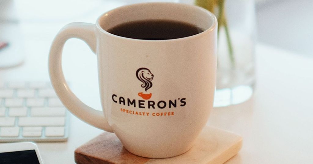 Coffee mug with Camer's Coffee logo on it, filled with coffee
