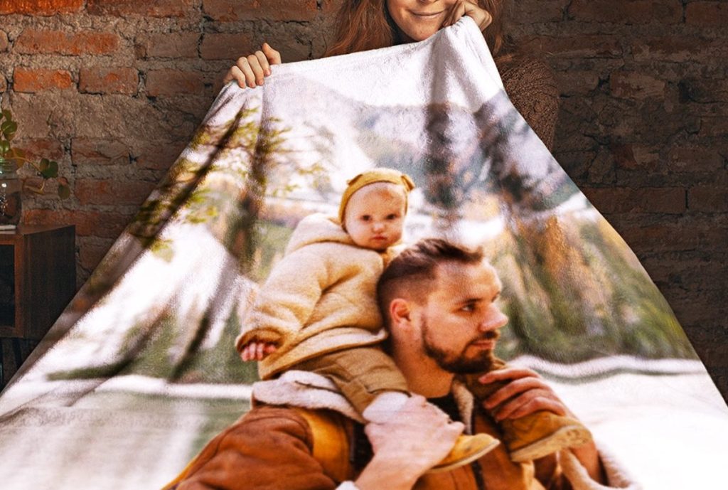 person holding up photo blanket