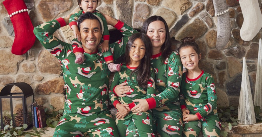 Family wearing Carters Matching Holiday Christmas Pajamas in front of fireplace