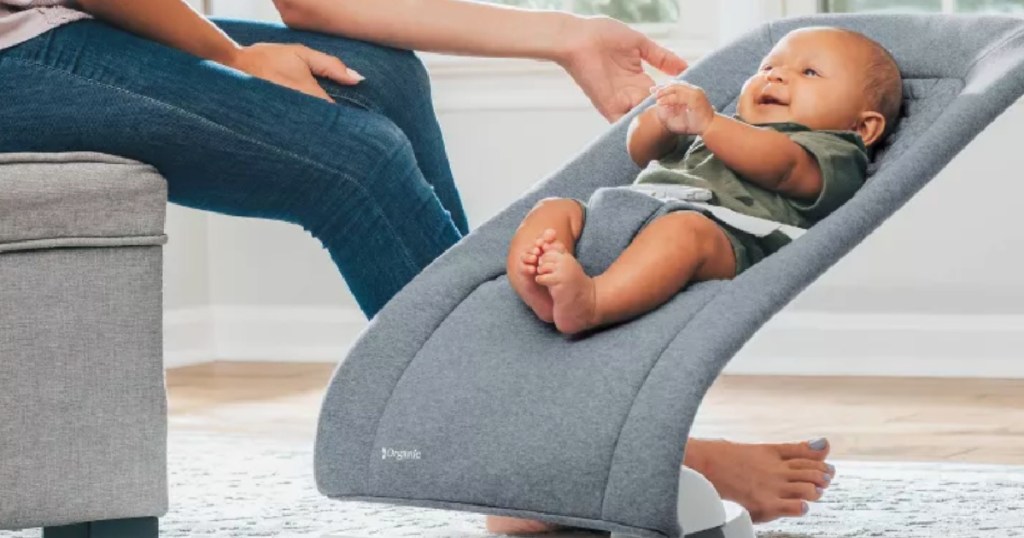 mom holding gray baby bouncer