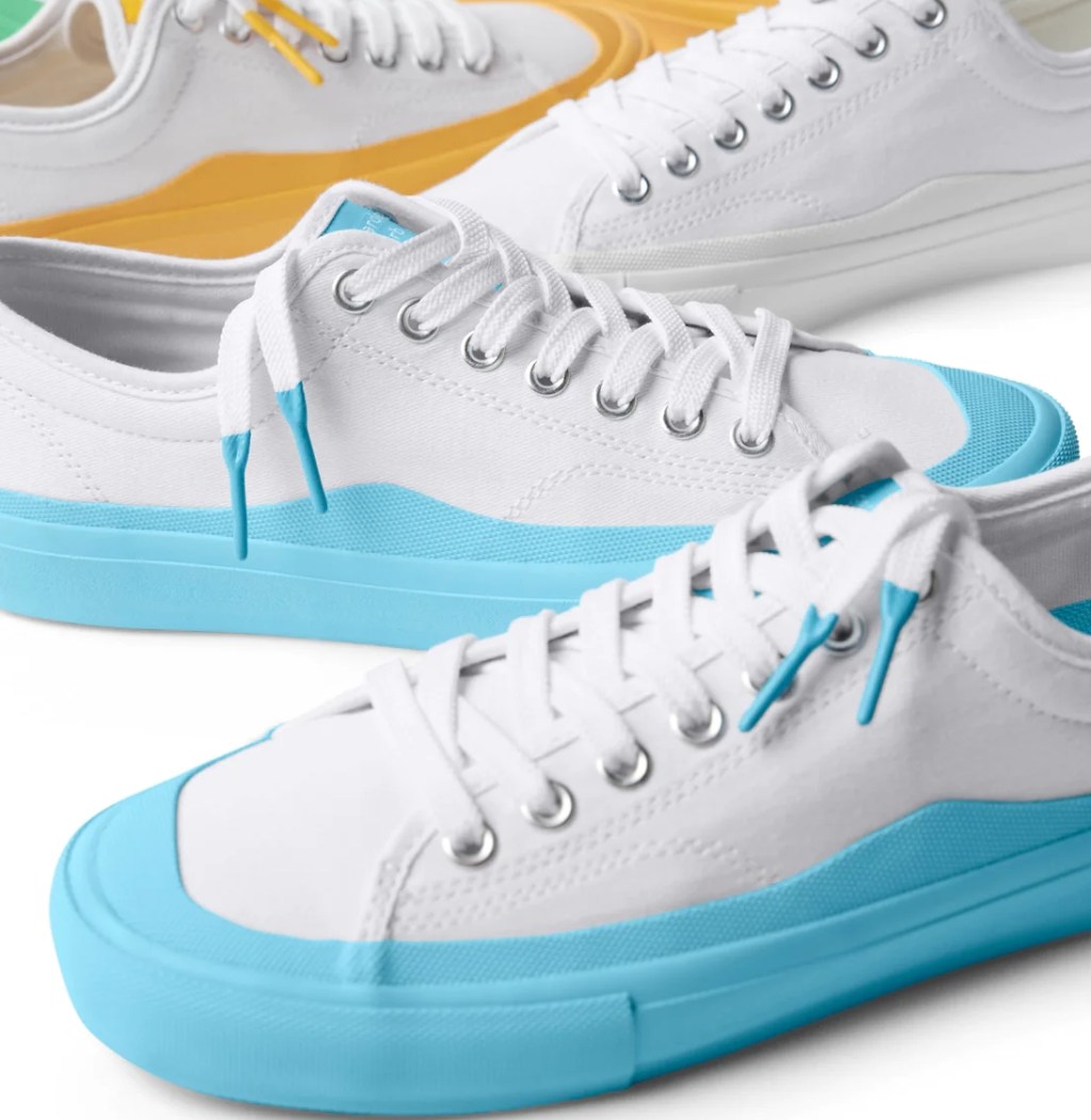 White and blue sneakers and a pair of white and yellow behind them