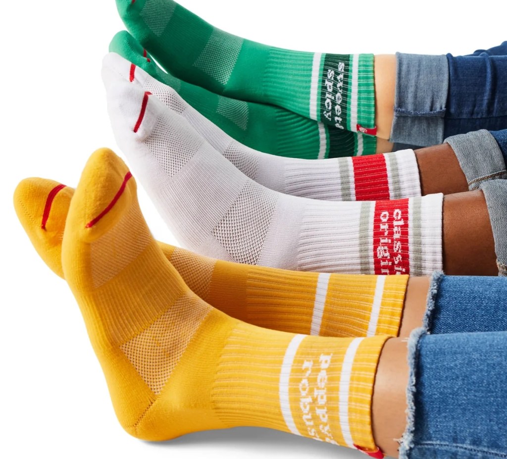 Three people wearing socks, the first in yellow, the second white and the third in green