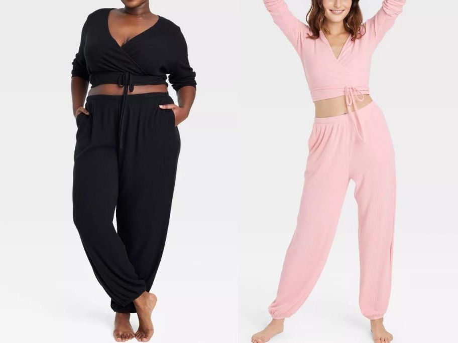 woman wearing black joggers and matching top and woman wearing pink joggers and matching top