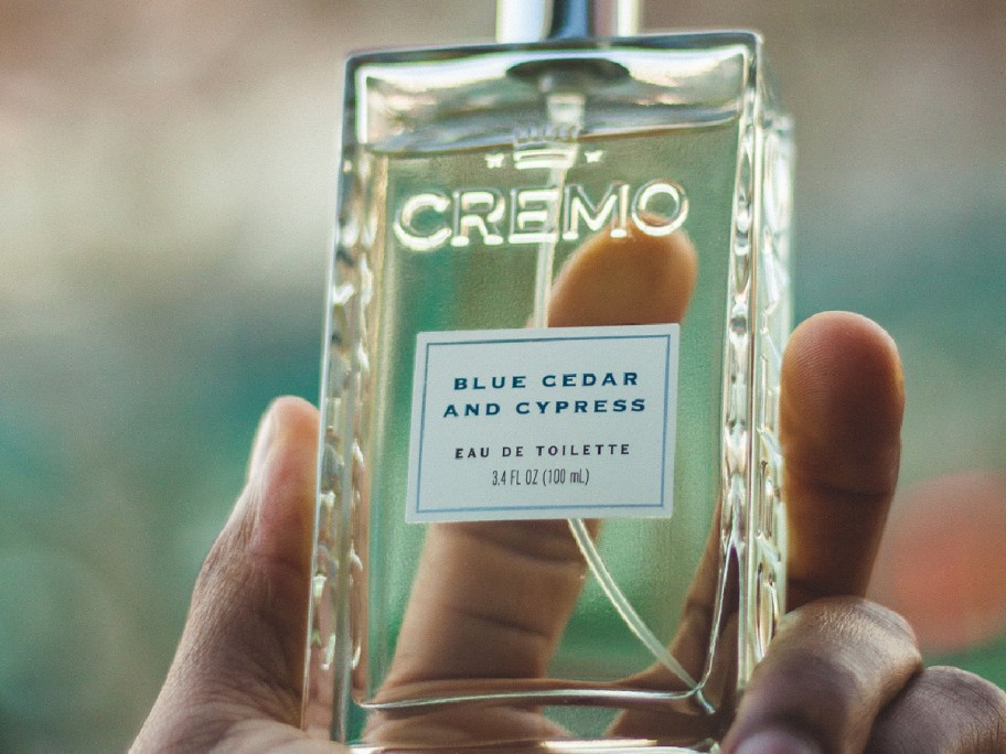 Cremo blue cedar and cypress cologne in her hands