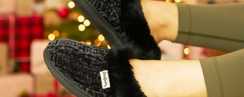 feet wearing black dearfoams slippers