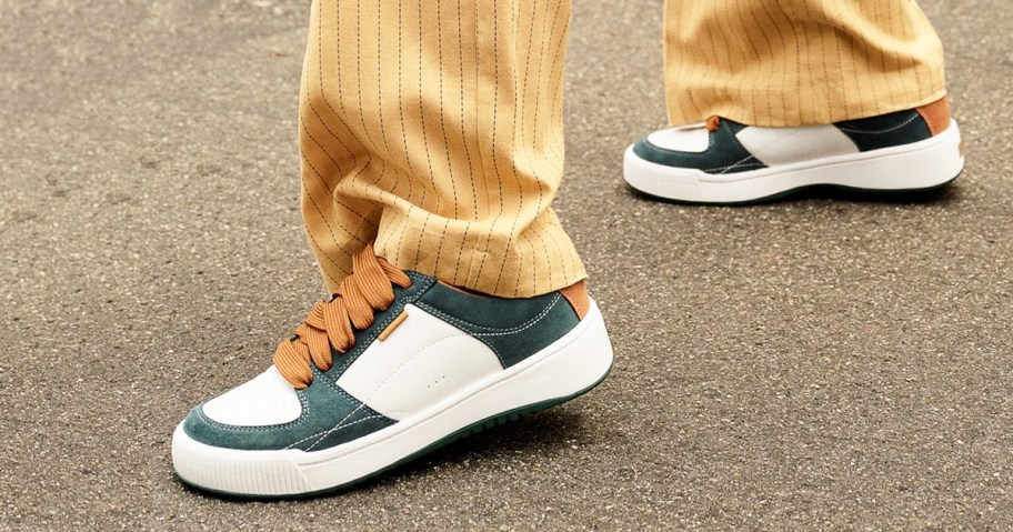 woman wearing white and green sneakers with pinstriped pants