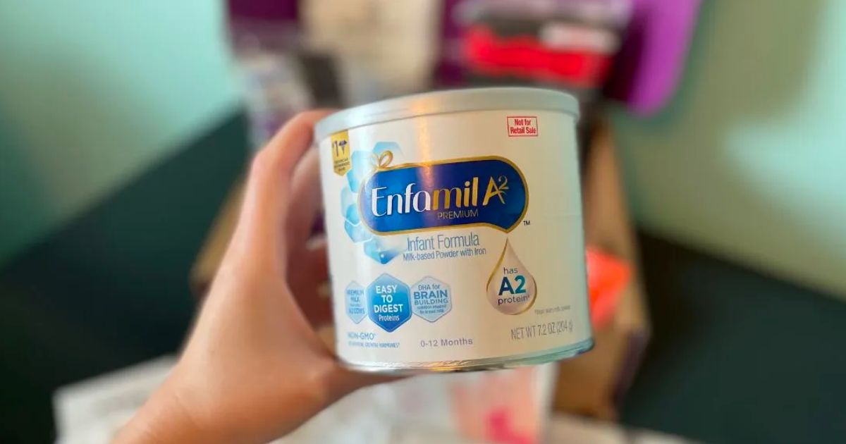  woman's hand holding a can of enfamil