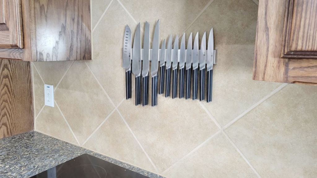 Magnetic knife holder hanging on the wall with knives on it