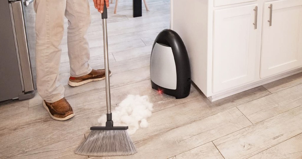 sweeping debris into black EyeVac Home Touchless Vacuum