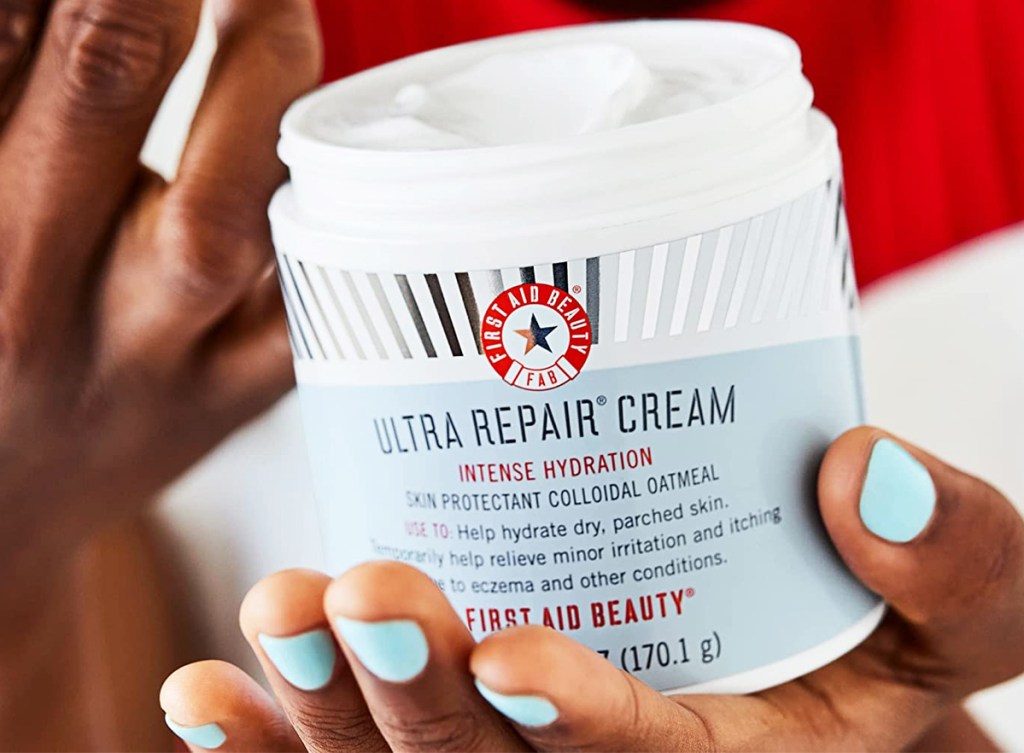 hands holding jar of First Aid Beauty Ultra Repair Cream