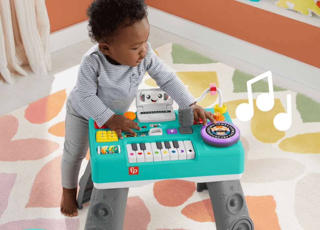 Boy playing with a Fisher-Price Laugh & Learn Mix & Learn DJ Table, Musical Learning Toy for Baby & Toddler