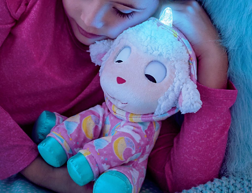 girl sleeping with FurReal Sweet Jammiecorn Lamb Interactive Plush Toy