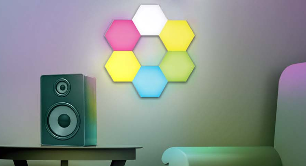GE Light kit panels lit up in a flower shape on the wall near a speaker and chair