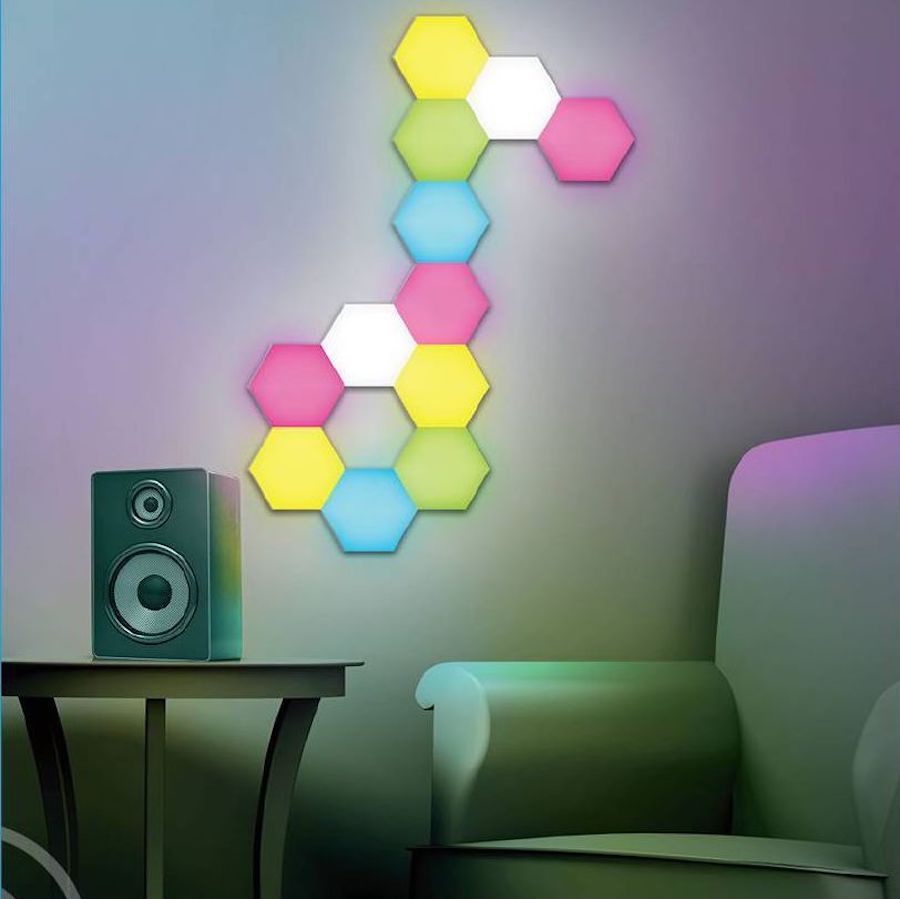 GE light kit panels lit up and assembled to look like a musical note on a wall near a speaker and chair