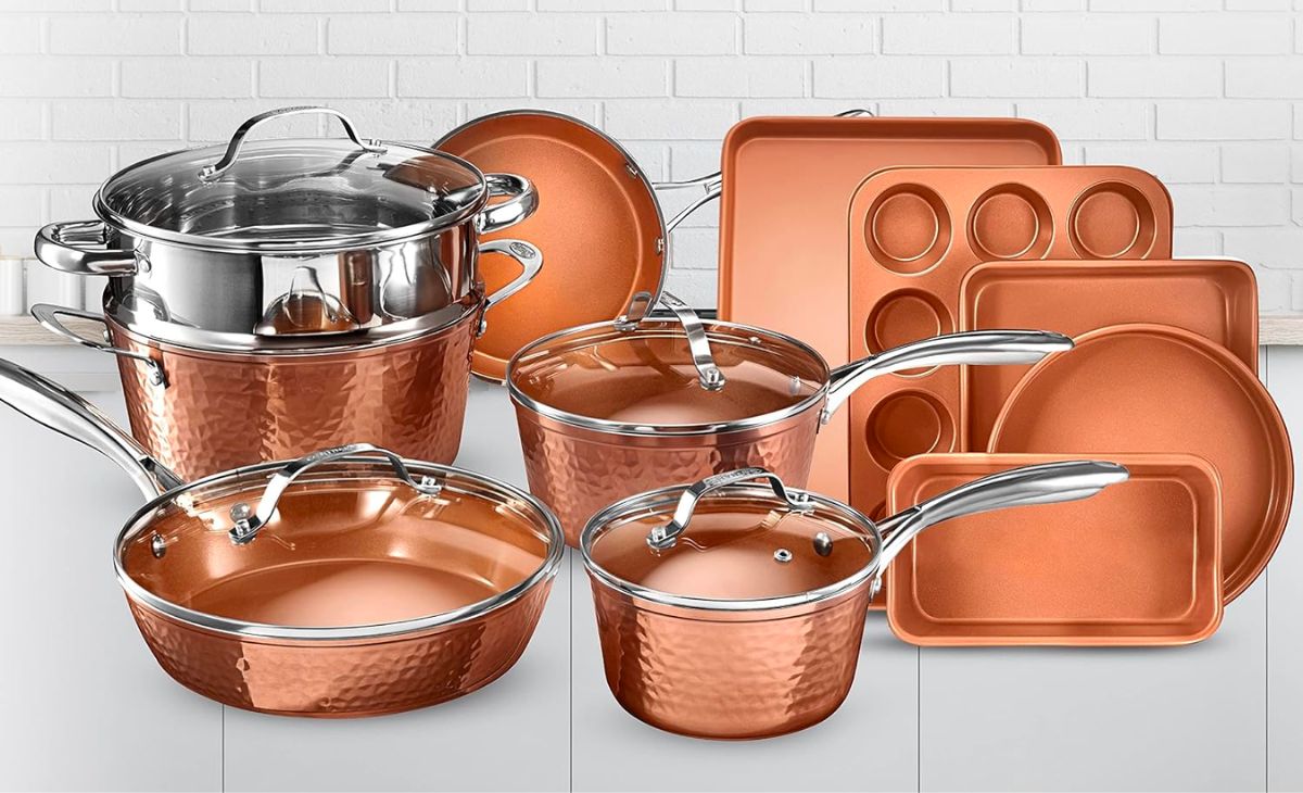 copper colored hammered cookware set on white background