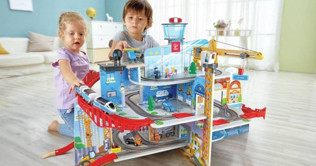 Boy and girl playing with railway play set