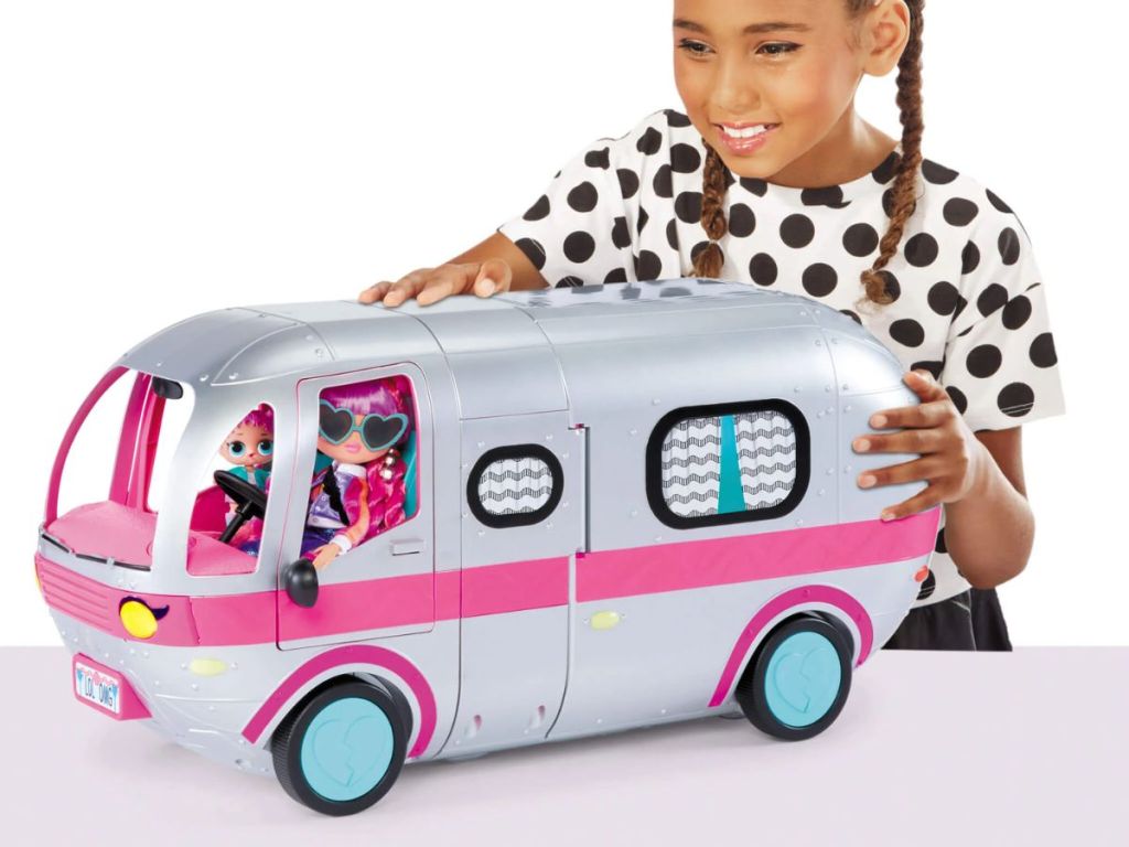 Little girl playing with a LOL Surprise OMG Glamper Fashion Camper Doll Playset with 55+ Surprises,