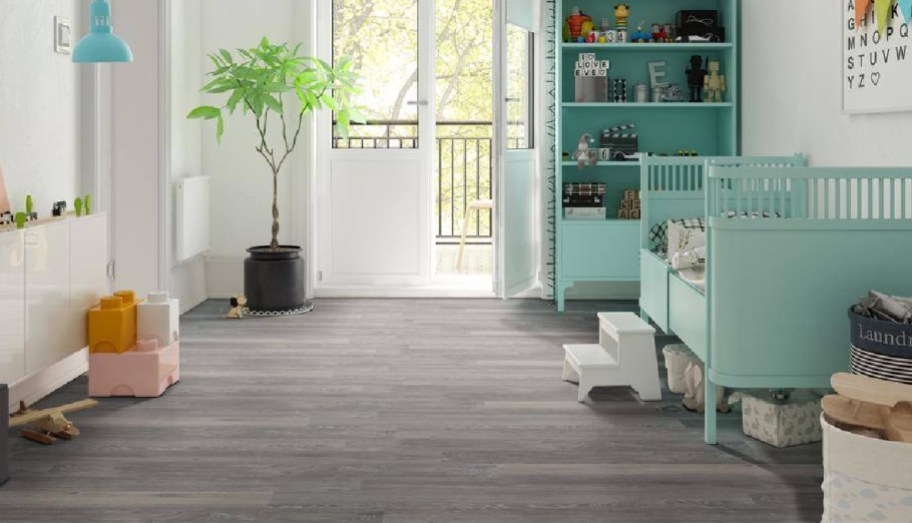 gray hardwood Home Depot flooring in kids room with teal crib and bookshelf