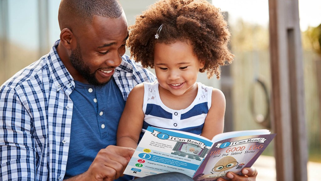 man reading I Can Read book to little girl