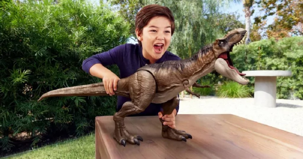 boy playing with large dinosaur figure