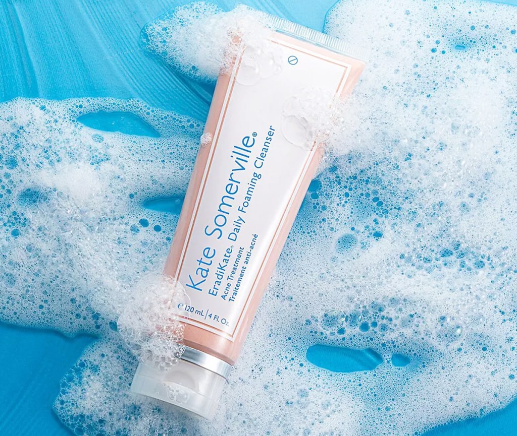 bottle of Kate Somerville EradiKate Daily Cleanser Acne Treatment with foam around it