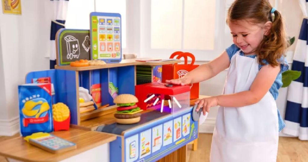child in front of pretend kitchen