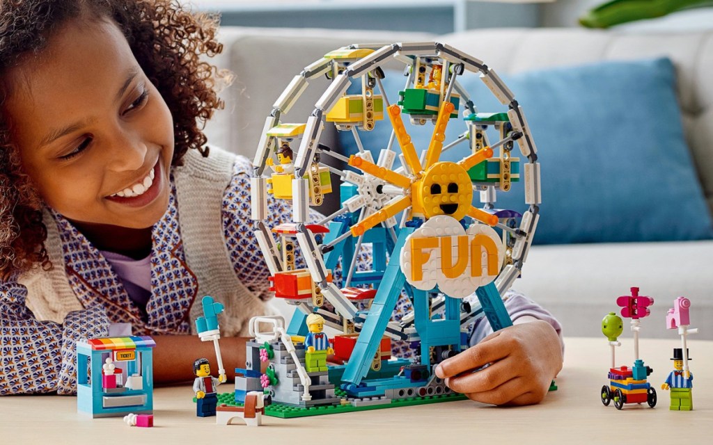 little girl playing with a LEGO Creator Ferris Wheel