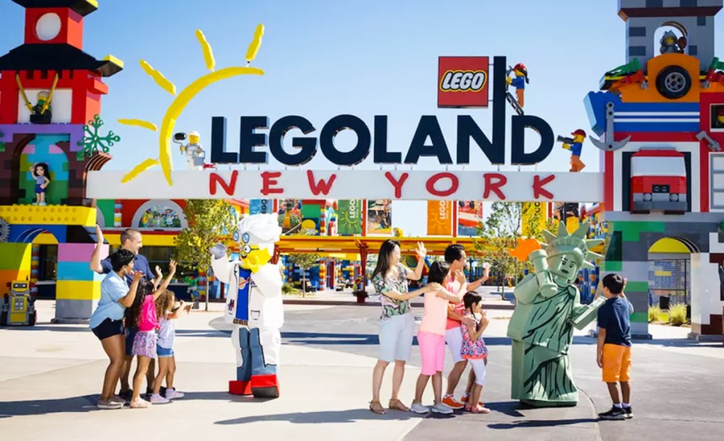 people standing in front of legoland new york sign