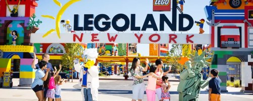 people standing in front of legoland new york sign