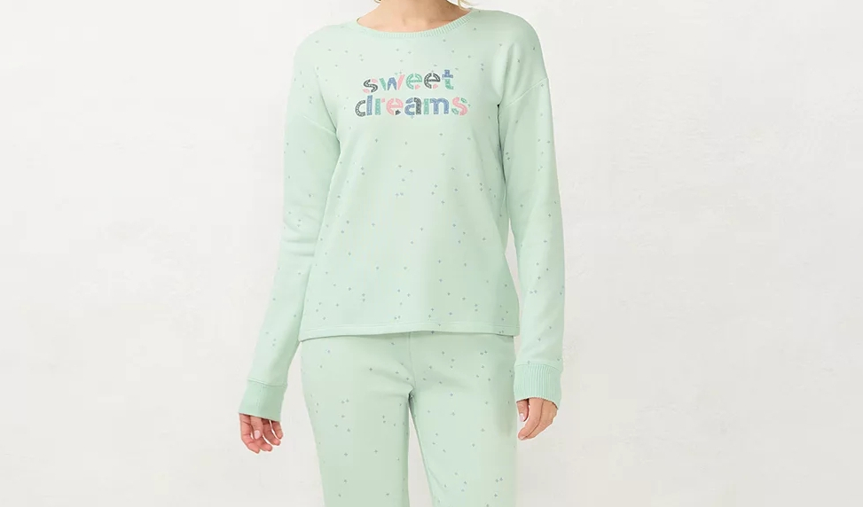 Woman wearing mint colored pajamas that say sweet dreams