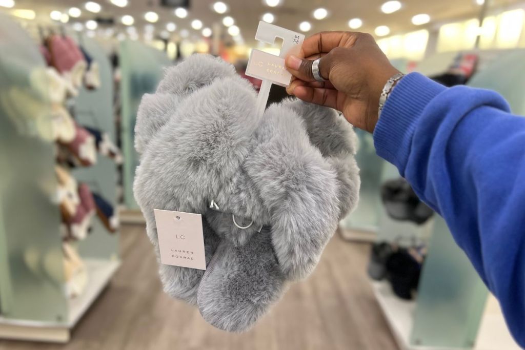 a woman's hand holding a pair of Lauren Conrad Womens Faux Fur Slippers in grey