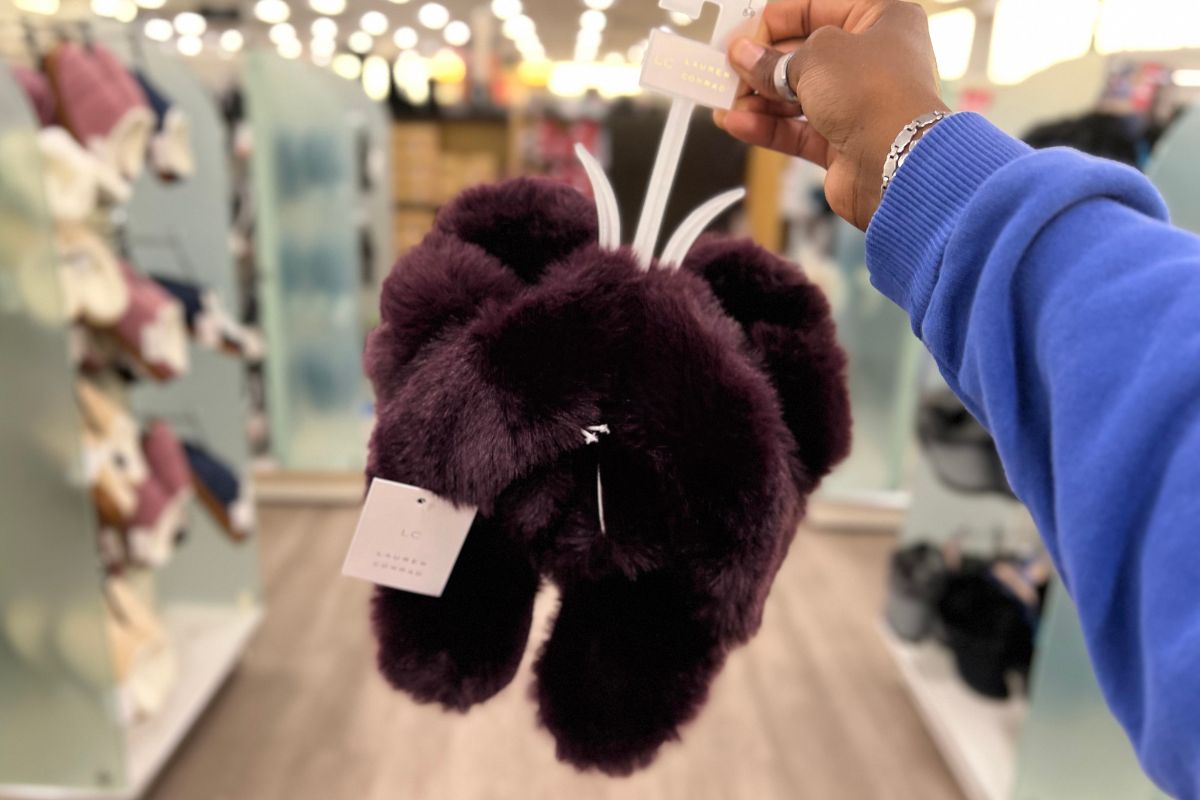 a woman's hand holding a pair of Lauren Conrad Women's Faux Fur Slippers in pickled beet