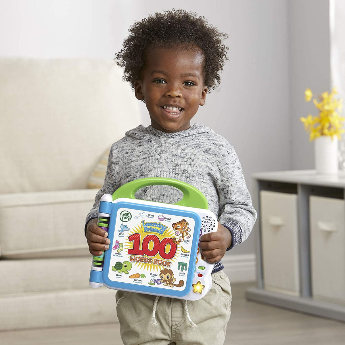 A boy holding a LeapFrog Learning Words Book