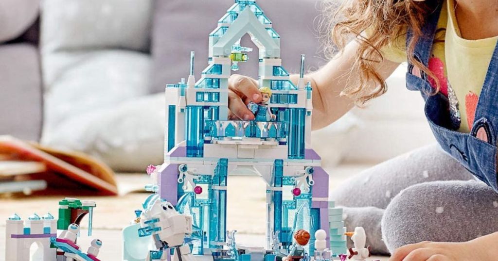 A little girl playing with the Ice Palace Lego set