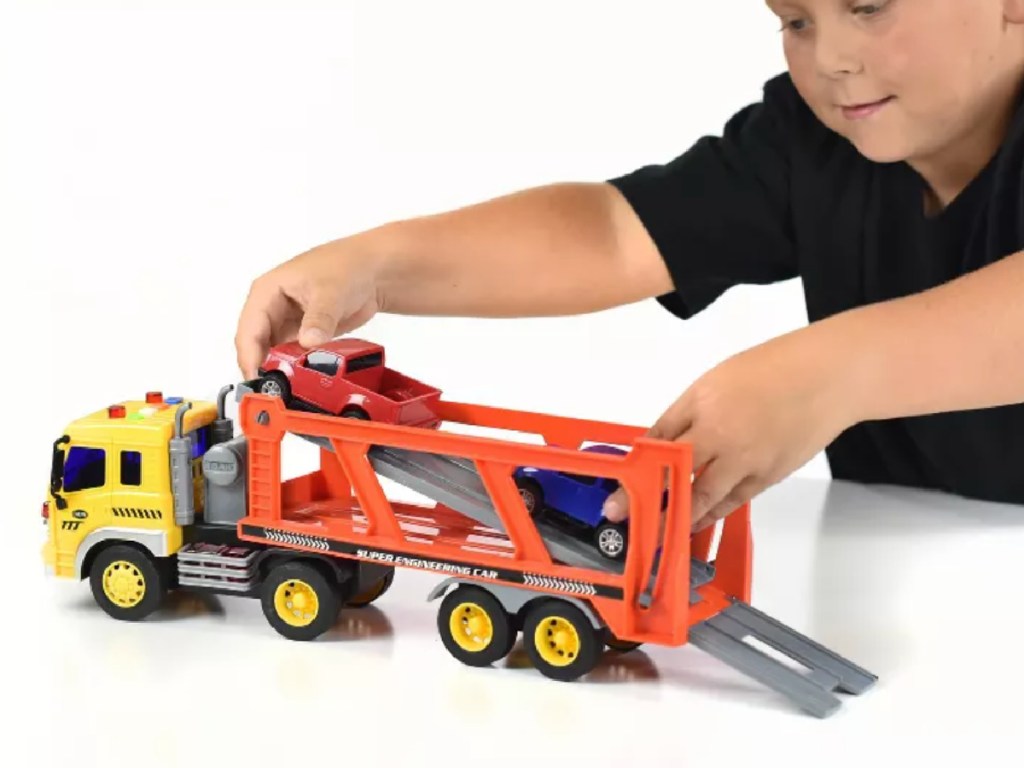 boy playing with toy truck trailer