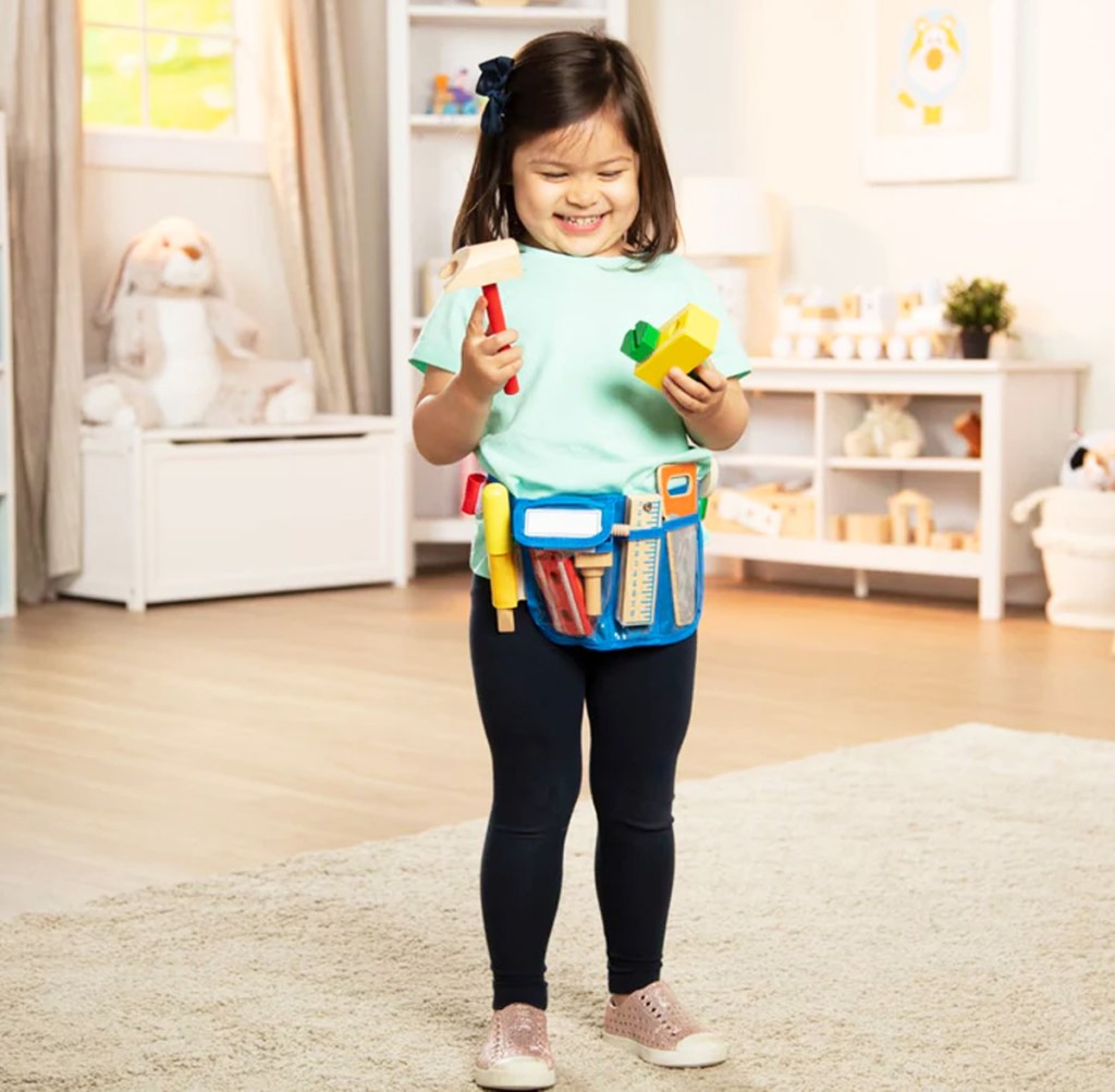 girl wearing a toy tool bag set