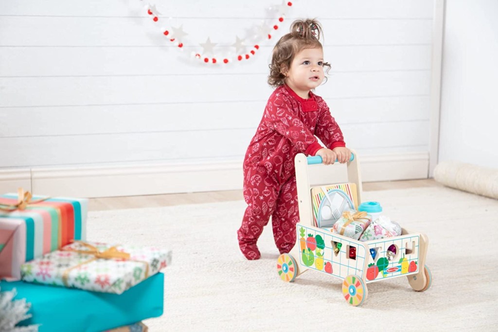 little girl pushing a Melissa and Doug Grocery Cart