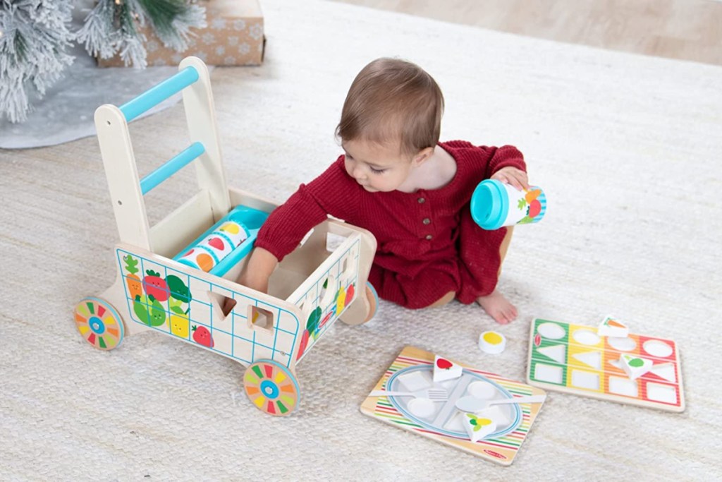 baby playing with a Melissa and Doug Wooden Grocery Cart