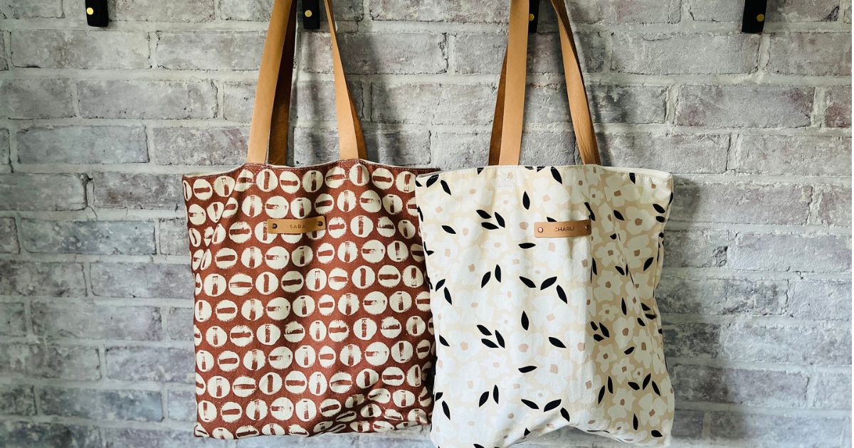 Two minted tote bags hanging up by the straps