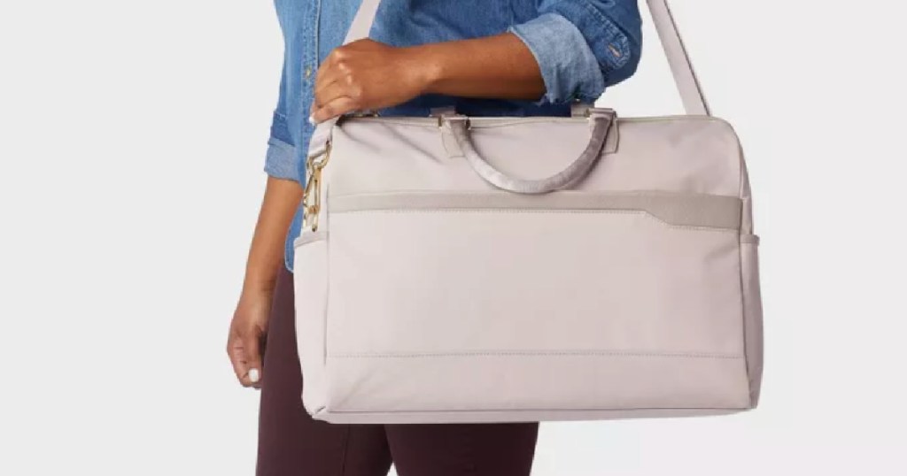 woman carrying tan travel bag 