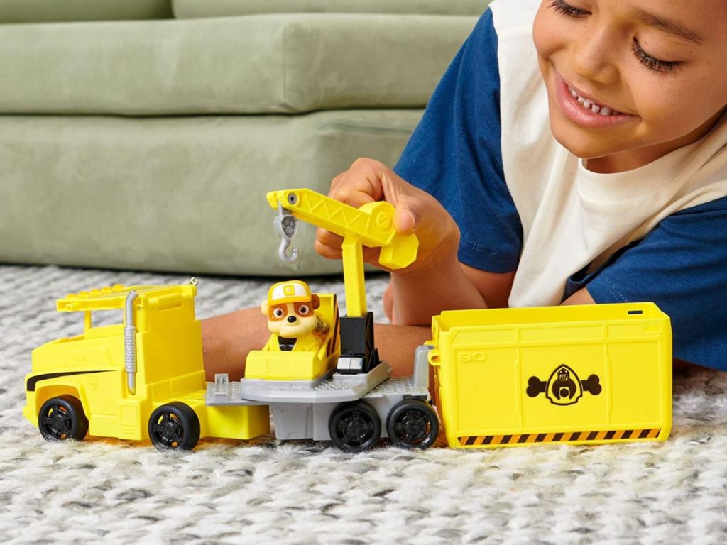 A child playing with a yellow truck