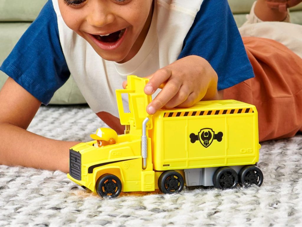 A child playing with a yellow truck