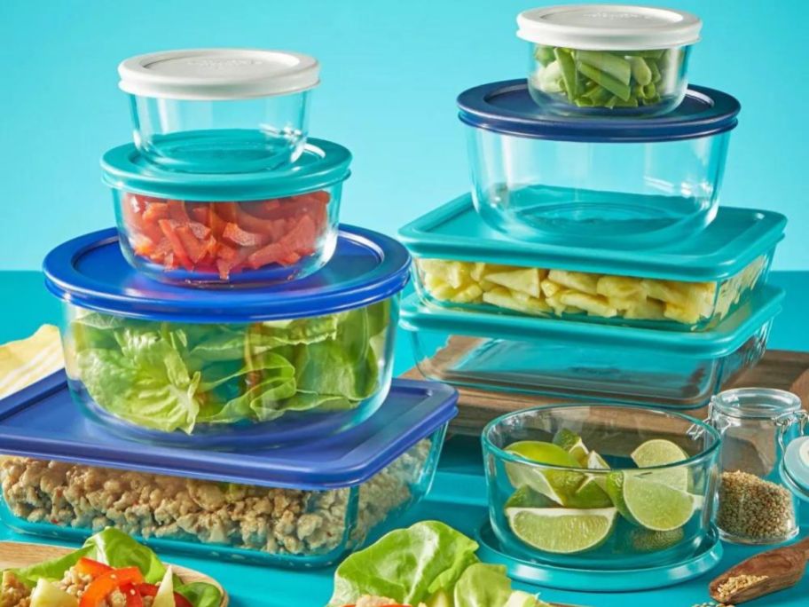 Two stacks of Pyrex Glass Storage containers with lids and food in them