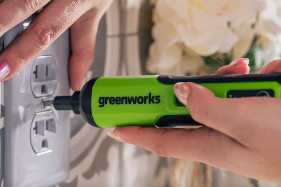 hand holding green electric screwdriver