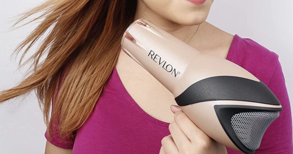 A woman drying her hair with a Revlon Rose Gold hairdryer 