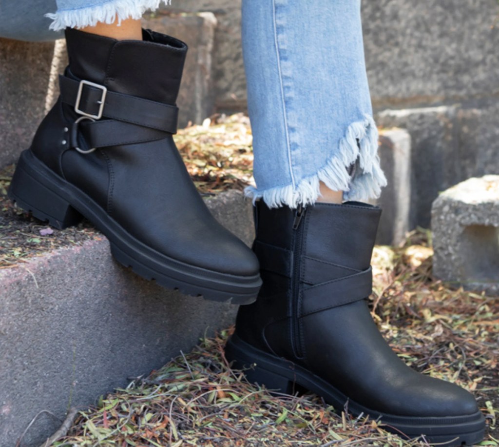 person wearing short black leather boots
